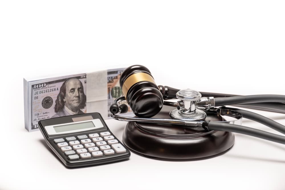 Gavel, cash, and stethoscope symbolizing medical malpractice litigation and valuing damages