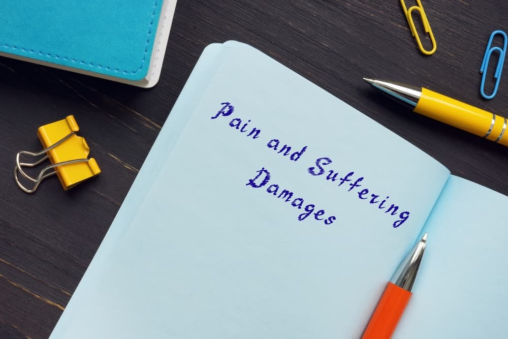 Pain and Suffering Damages written with pen on a notebook