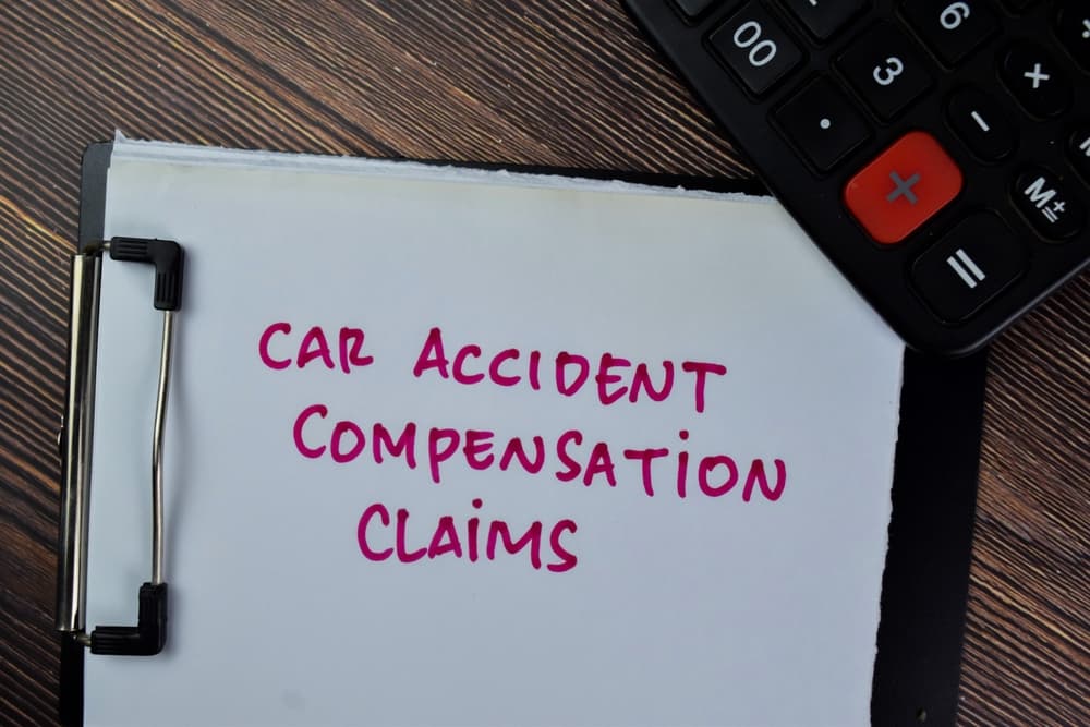 Car Accident Compensation Claims write on paperwork isolated on Wooden Table.